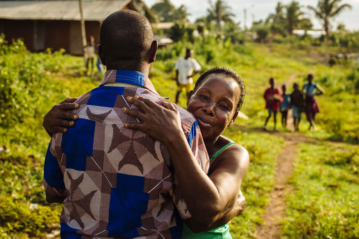 A former refugee from Côte d'Ivoire is embraced by his aunt upon returning home A former refugee from Côte d'Ivoire hugs his aunt.